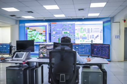 Operador trabalha em uma moderna sala de controle, monitorando sistemas tecnológicos.